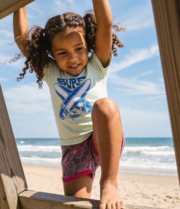 Child on a wooden staircase at the beach with ocean view